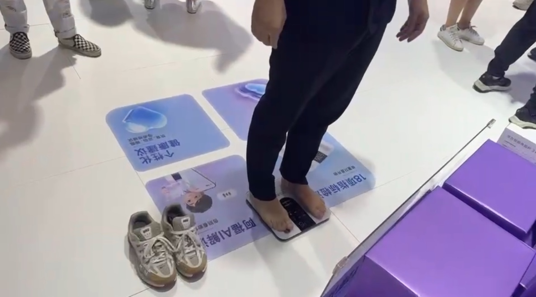 (图:WAIC现场,一名参展观众体验智能体脂秤)