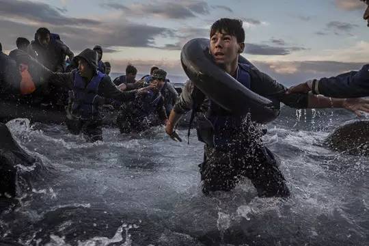 2015年10月1日，希腊莱斯博斯岛，在乘坐橡皮筏从土耳其出发、经历了大风和波涛汹涌的海面后，难民们抵达了希腊的海岸