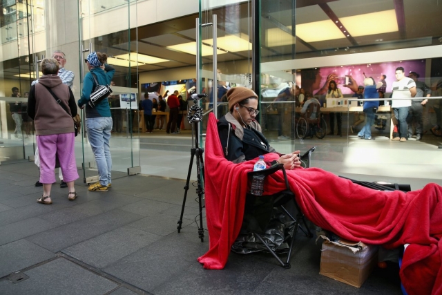 a-man-passes-time-in-front-of-an-apple-store-in-sydney